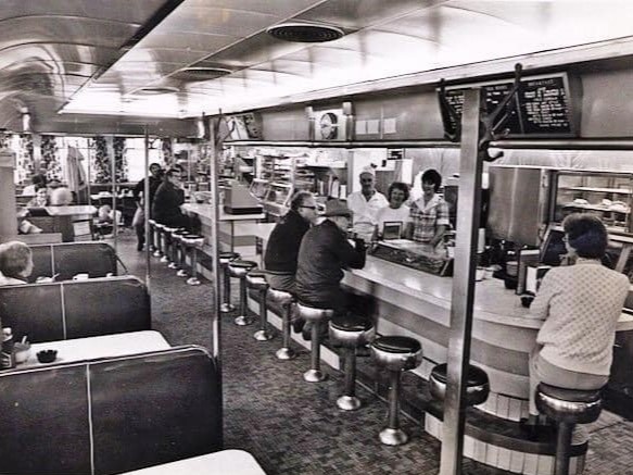 Black and white photo of Don Sr. behind the counter in the 1940's
